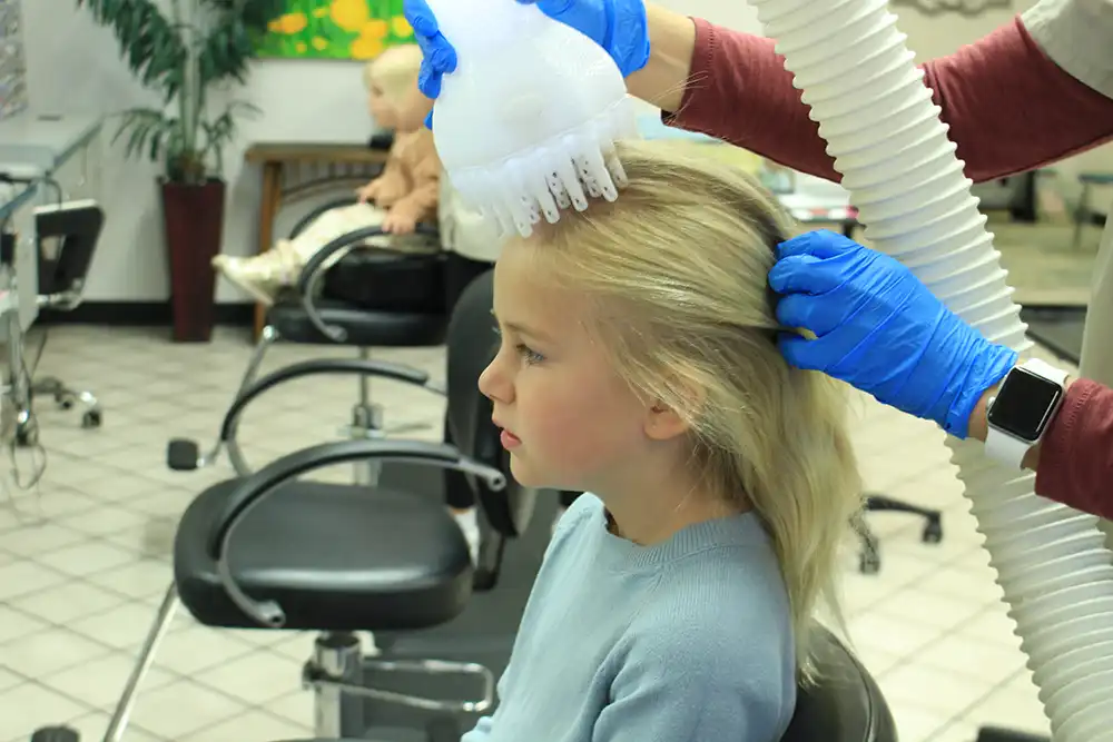 Child receiving lice treatment with heated air technology at Lice Beware, showcasing the professional lice removal process in a treatment center.